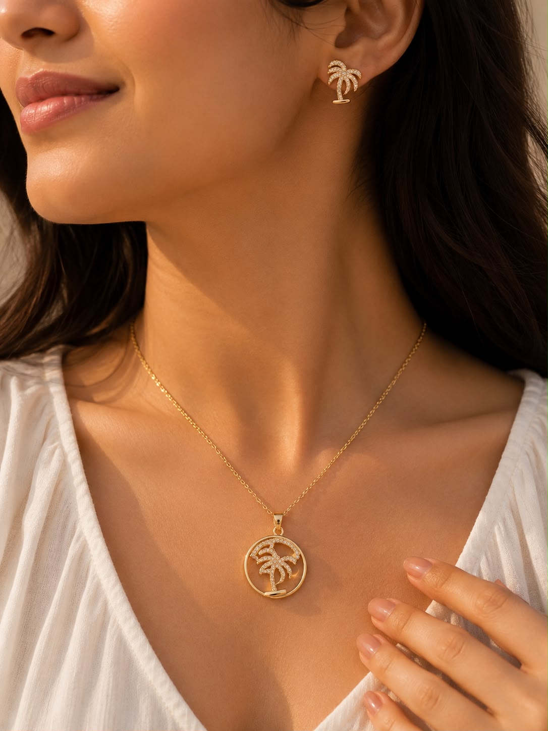 Model wearing palm tree CZ necklace and earrings set in gold tone