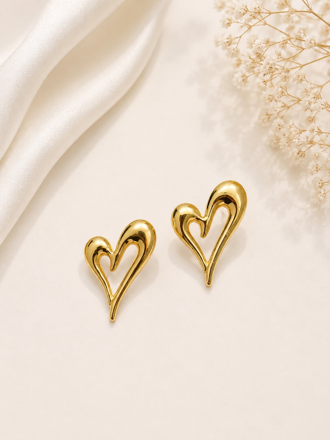 Gold open heart stud earrings flat lay