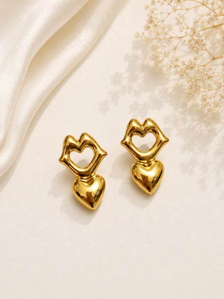 Gold lips and heart drop earrings flat lay