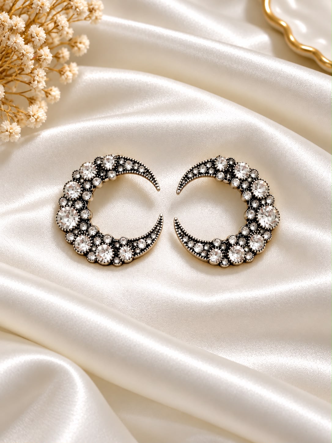Crescent earrings with clear stones in a dark silver-tone setting