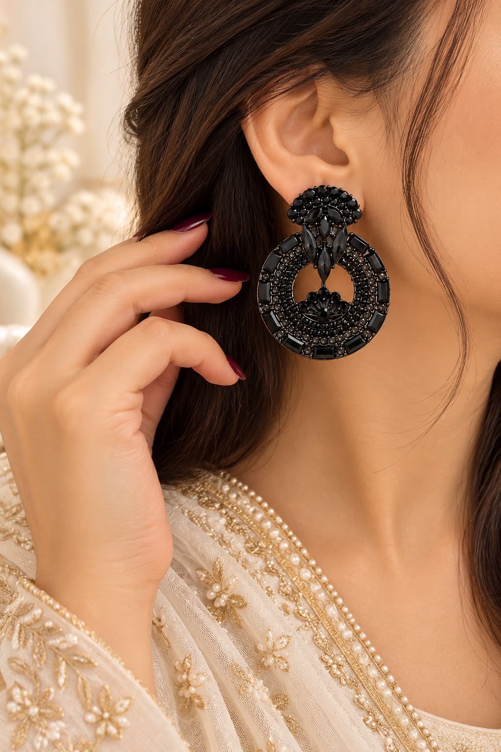 Model wearing black circular statement earrings with a sculptural stone cluster