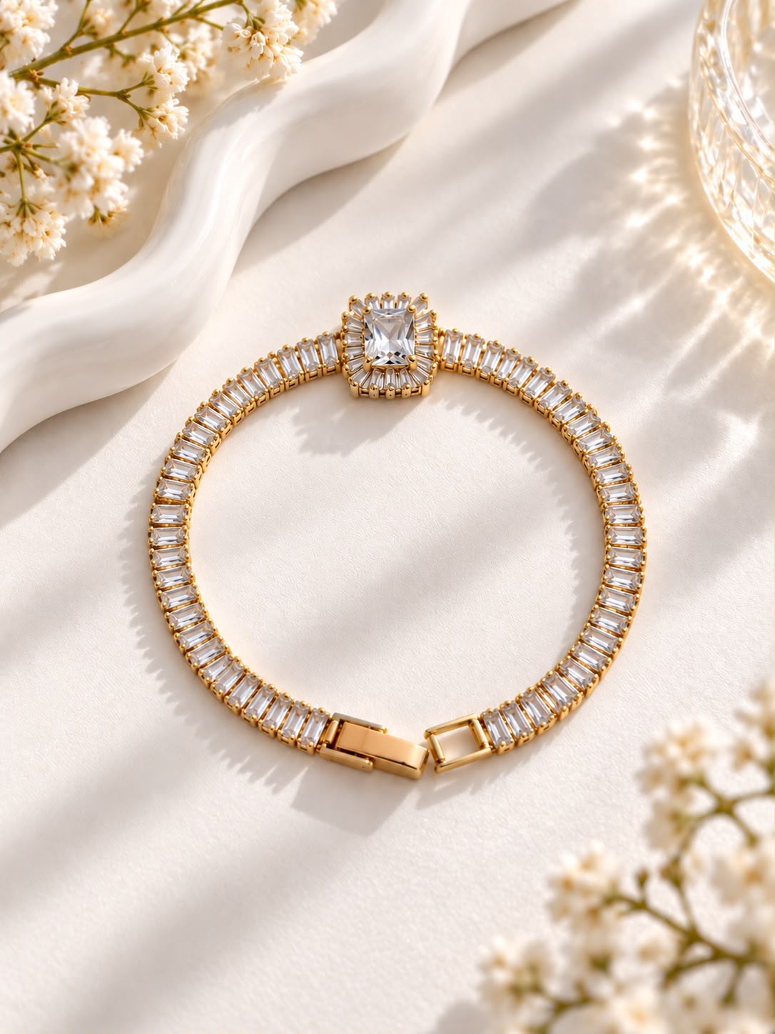 Gold-tone bracelet with a rectangular clear centre stone and rectangular stone halo
