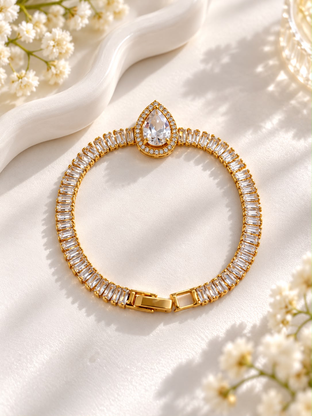 Gold-tone bracelet with a teardrop halo centrepiece and rectangular clear stones