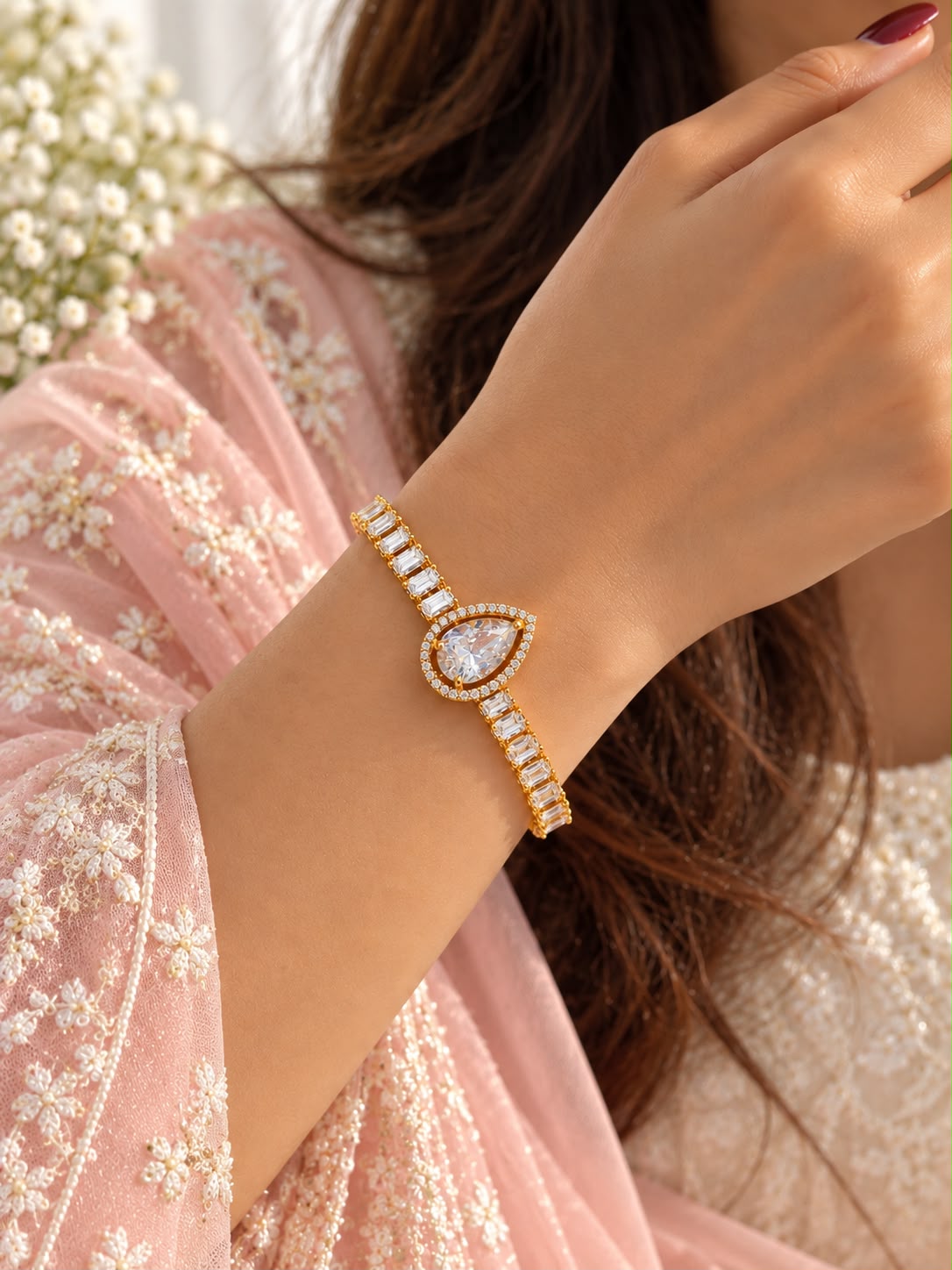 Aurelia gold-tone teardrop halo bracelet worn with a pink embroidered outfit