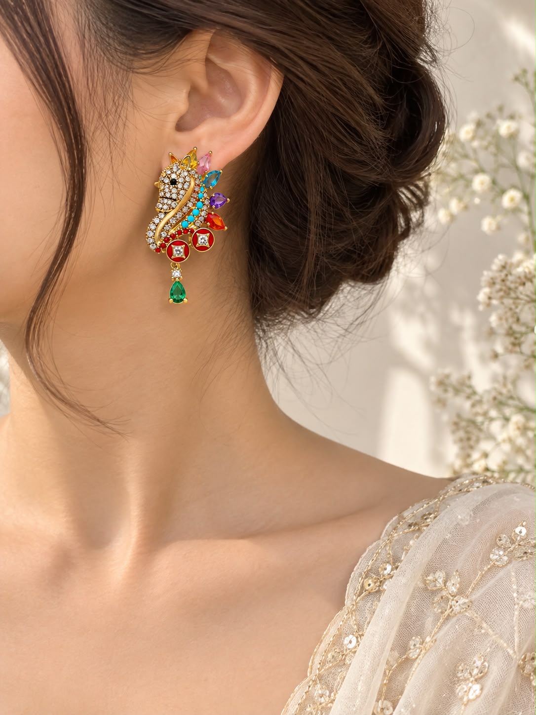 Model wearing unicorn crystal and enamel drop earrings with an embroidered saree